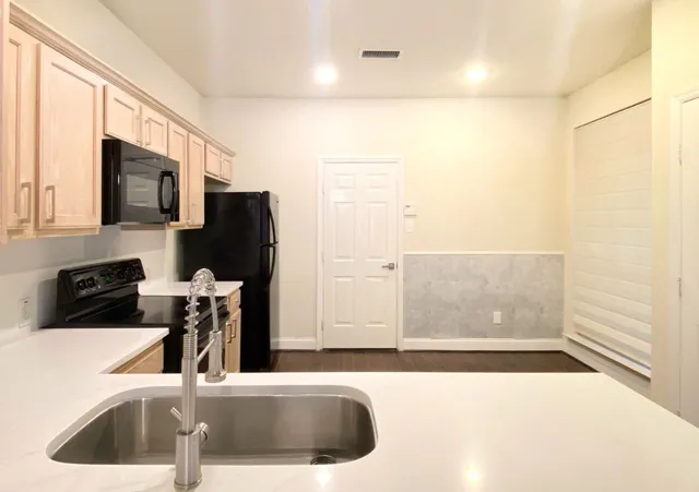a kitchen with kitchen island a sink appliances and cabinets