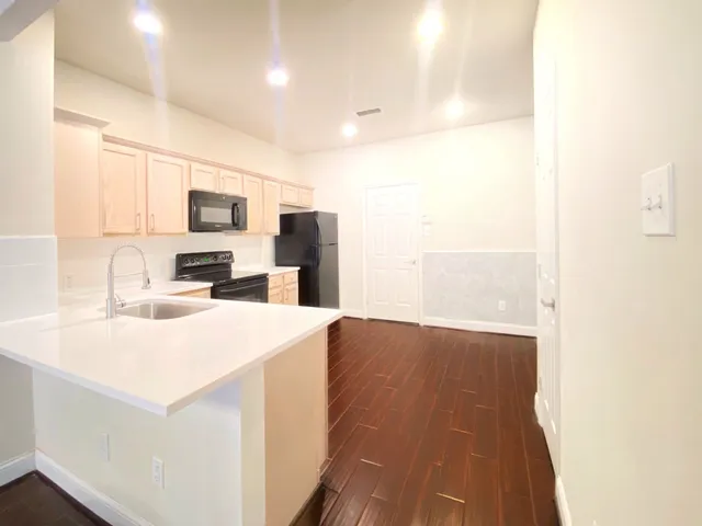 a kitchen with a refrigerator and a stove top oven