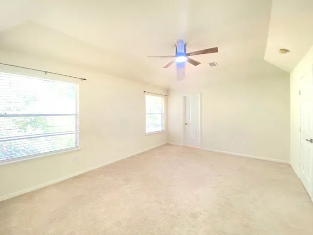 an empty room with a window and a fan