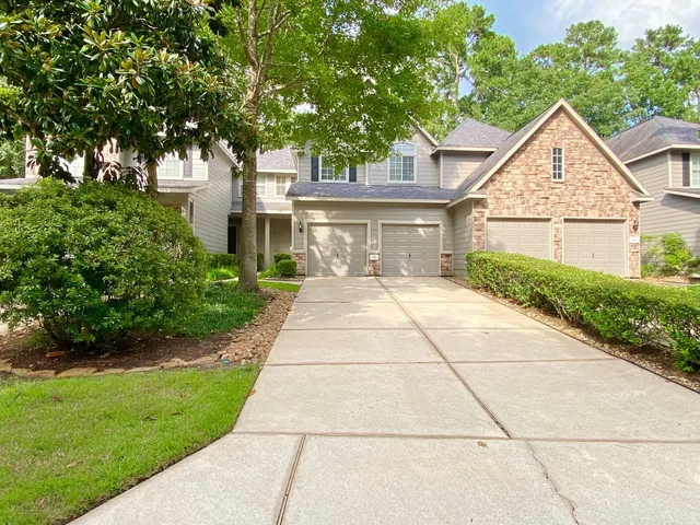 a view of white house with a yard and potted plants
