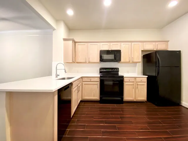 a kitchen with a refrigerator and a stove top oven
