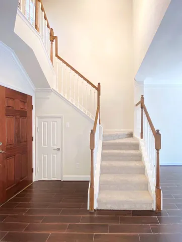a view of staircase with white walls and railing