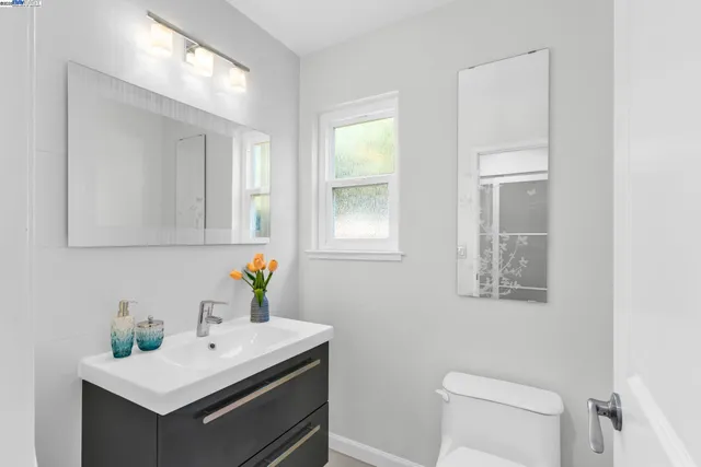 a bathroom with a sink a toilet and mirror