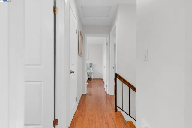 a view of a hallway with wooden floor and staircase