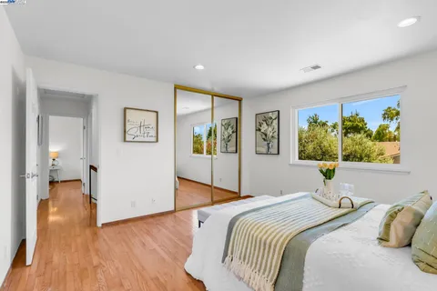 a bedroom with a bed and a painting on the wall