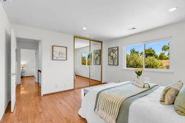 a bedroom with a bed and a painting on the wall