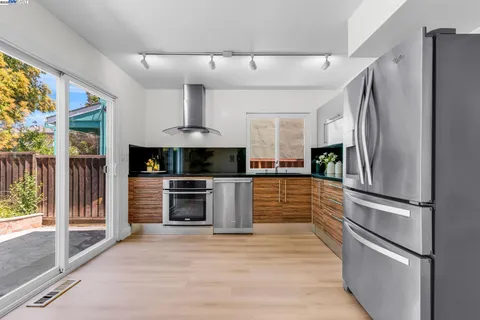 a kitchen with stainless steel appliances white cabinets and a window