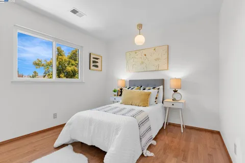 a bedroom with a bed and wooden floor