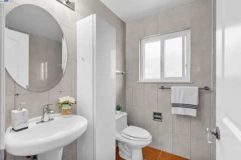 a bathroom with a sink a toilet and a mirror