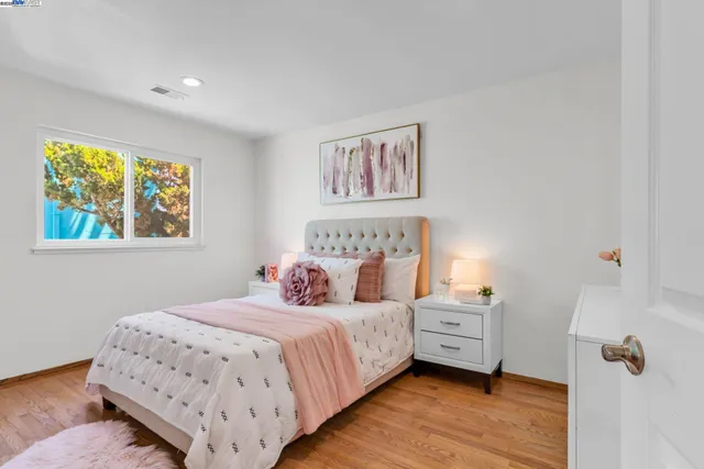 a bedroom with a bed and a painting on the wall