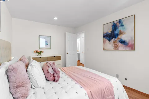 a bedroom with a bed and a painting on the wall