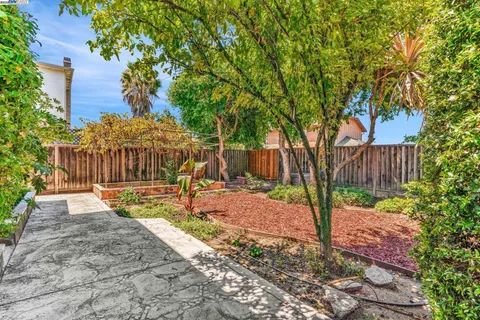 a view of a backyard with table and chairs and wooden fence