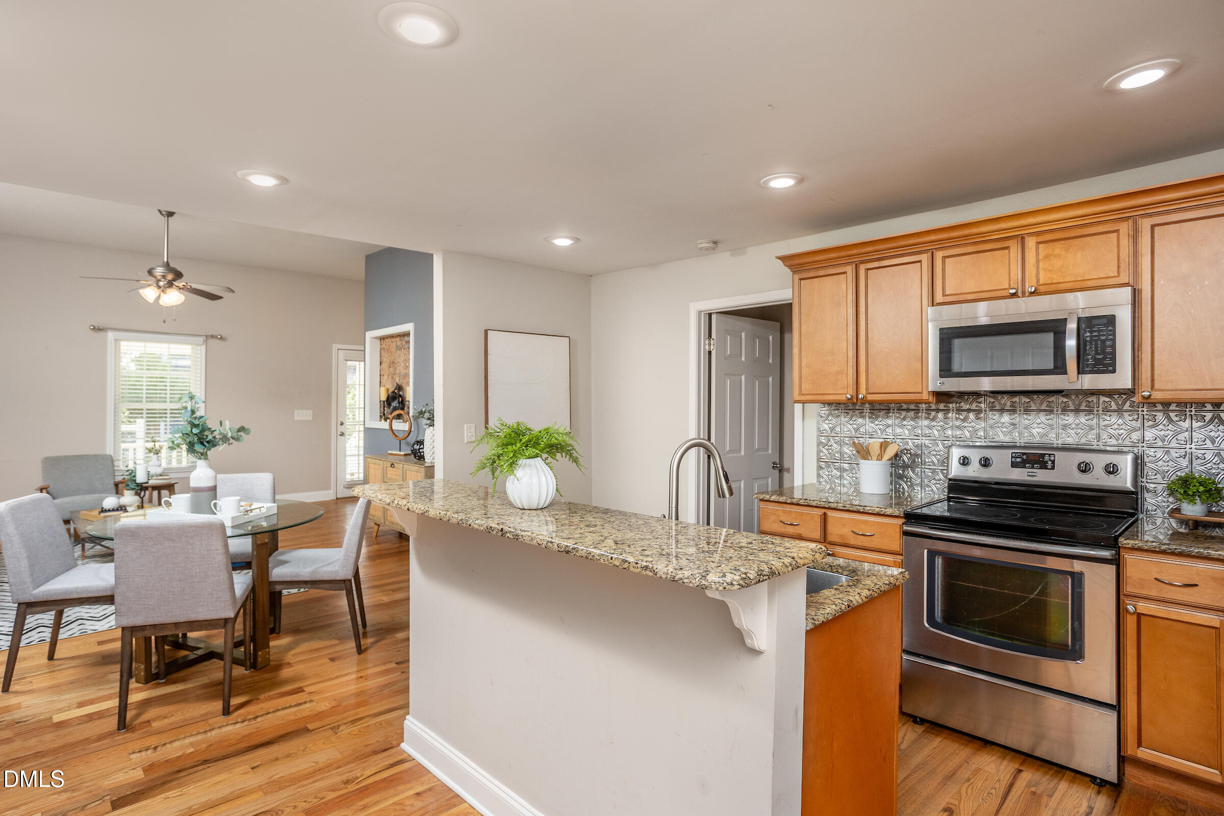 305 Freeman Street Raleigh, NC 27601 - Photo 7 of 15 a kitchen with stainless steel appliances granite countertop a stove top oven a sink dishwasher a dining table and chairs with wooden floor