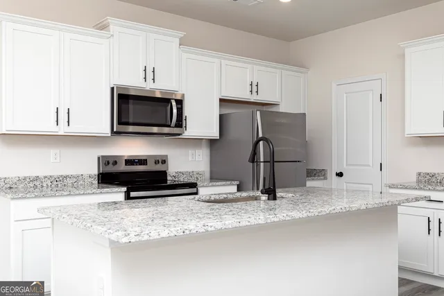a kitchen with granite countertop a sink and a stove top oven