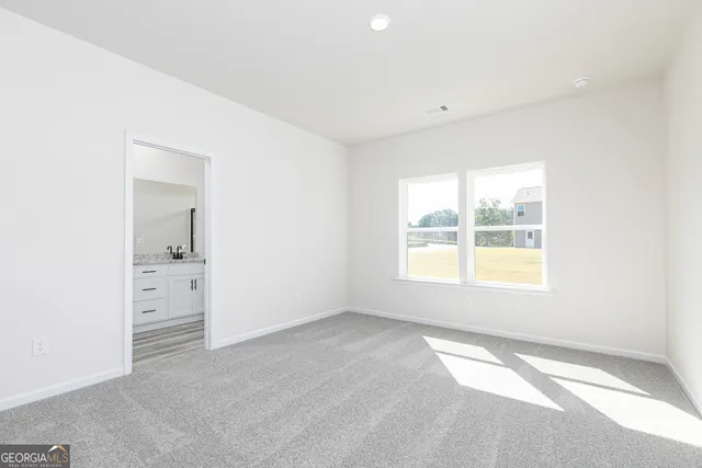 an empty room with a window and a bathroom