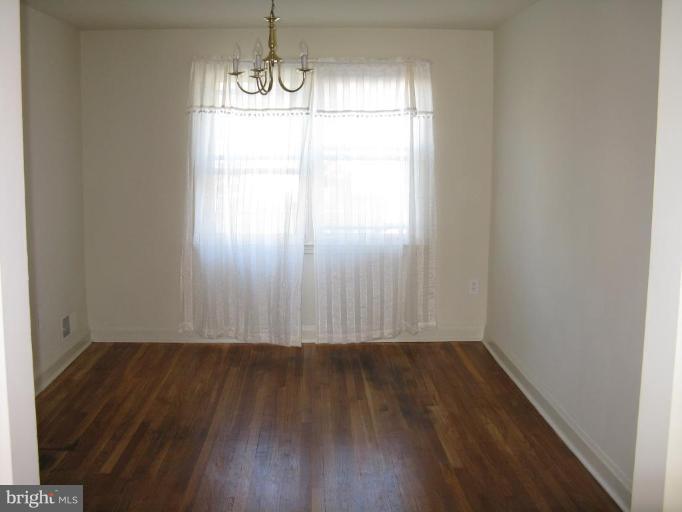 1925 Frames Road Dundalk, MD 21222 - Photo 6 of 14 an empty room with wooden floor and windows