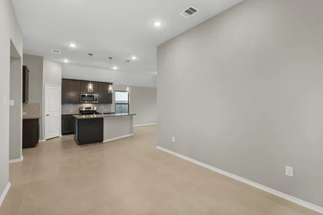 a kitchen with stainless steel appliances a refrigerator and a stove top oven