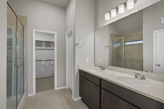 a bathroom with a double vanity sink mirror and shower