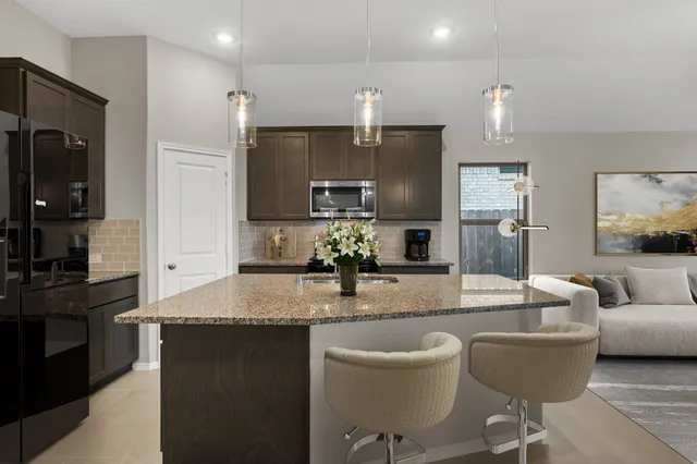 a kitchen with a dining table chairs refrigerator and cabinets
