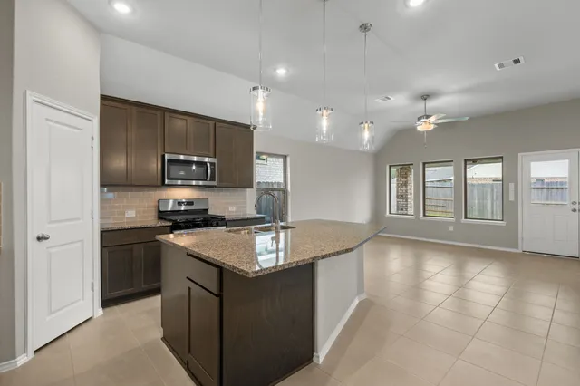 a kitchen with stainless steel appliances granite countertop a sink stove and refrigerator