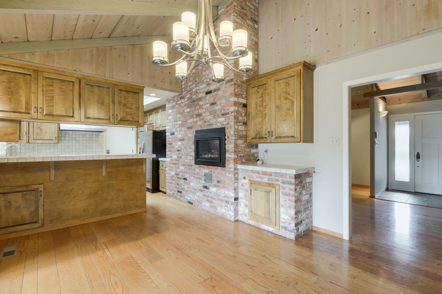 390 Cherry Avenue Los Altos, CA 94022 - Photo 6 of 27 a view of a livingroom with a fireplace a chandelier and wooden floor