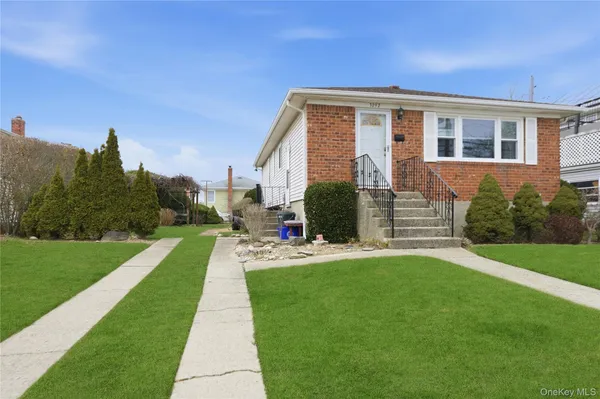 a front view of a house with a yard and trees