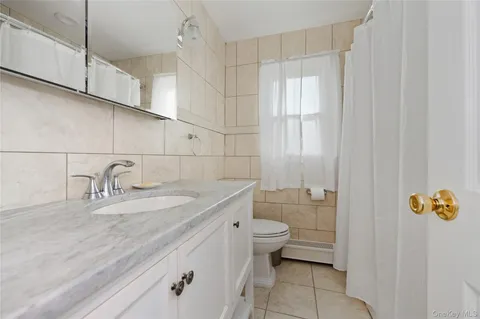 a bathroom with a granite countertop sink a toilet and bathtub