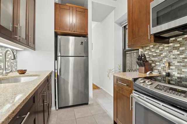 a kitchen with stainless steel appliances granite countertop a refrigerator and a sink