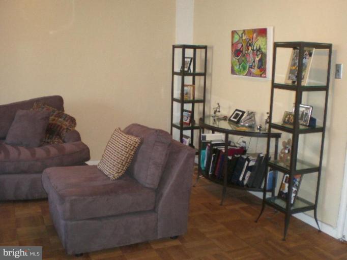 4100 W Street Northwest, Unit 510 Washington, DC 20007 - Photo 4 of 12 a living room with furniture a bookshelf and a window