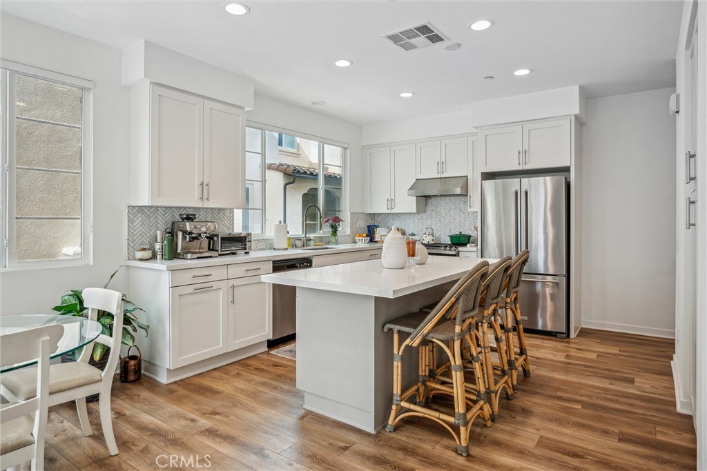 318 Ford Road Costa Mesa, CA 92627 - Photo 7 of 20 a kitchen with a table chairs refrigerator and cabinets
