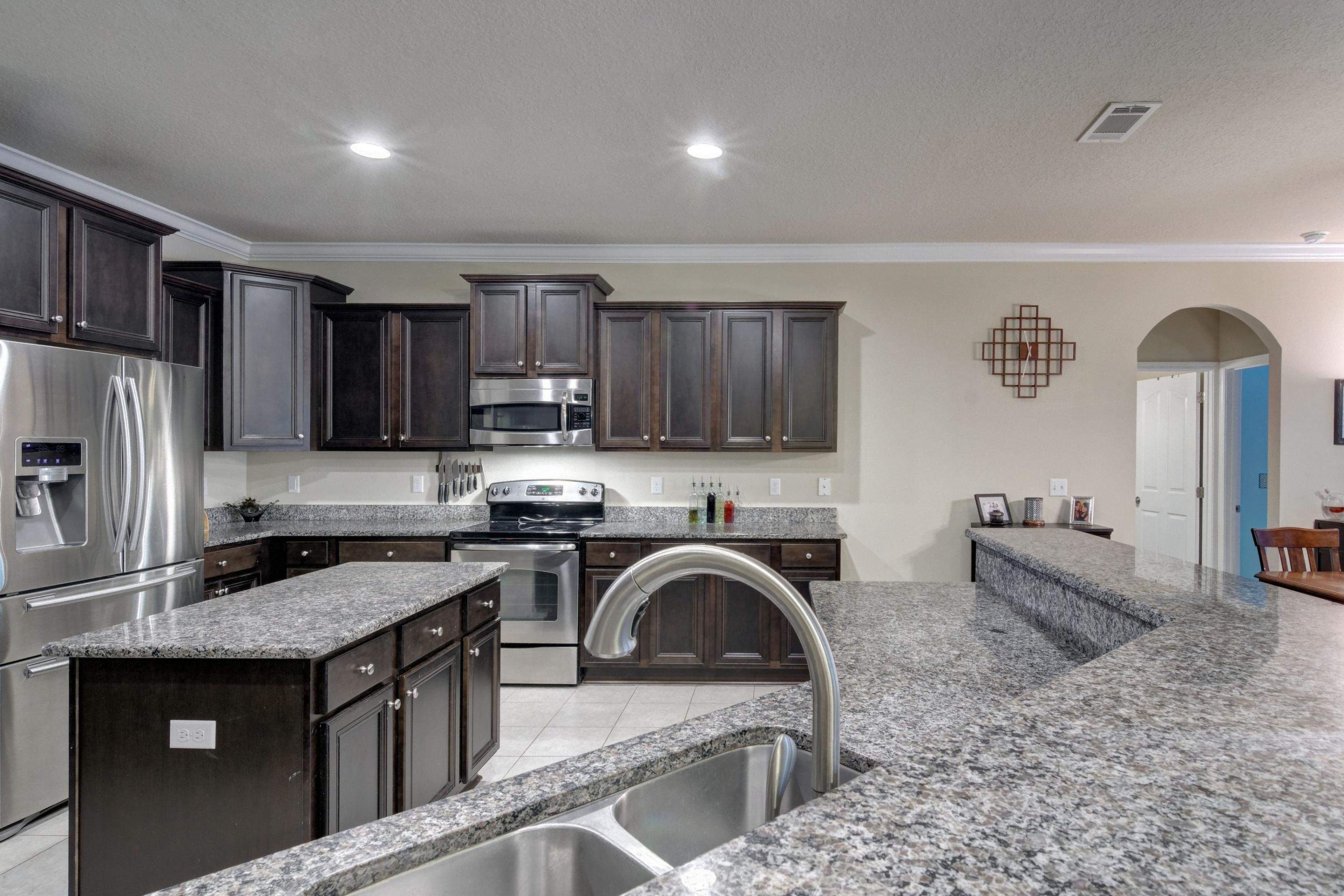 646 Red Fern Road Crestview, FL 32536 - Photo 29 of 64 a kitchen with granite countertop a stove sink and refrigerator