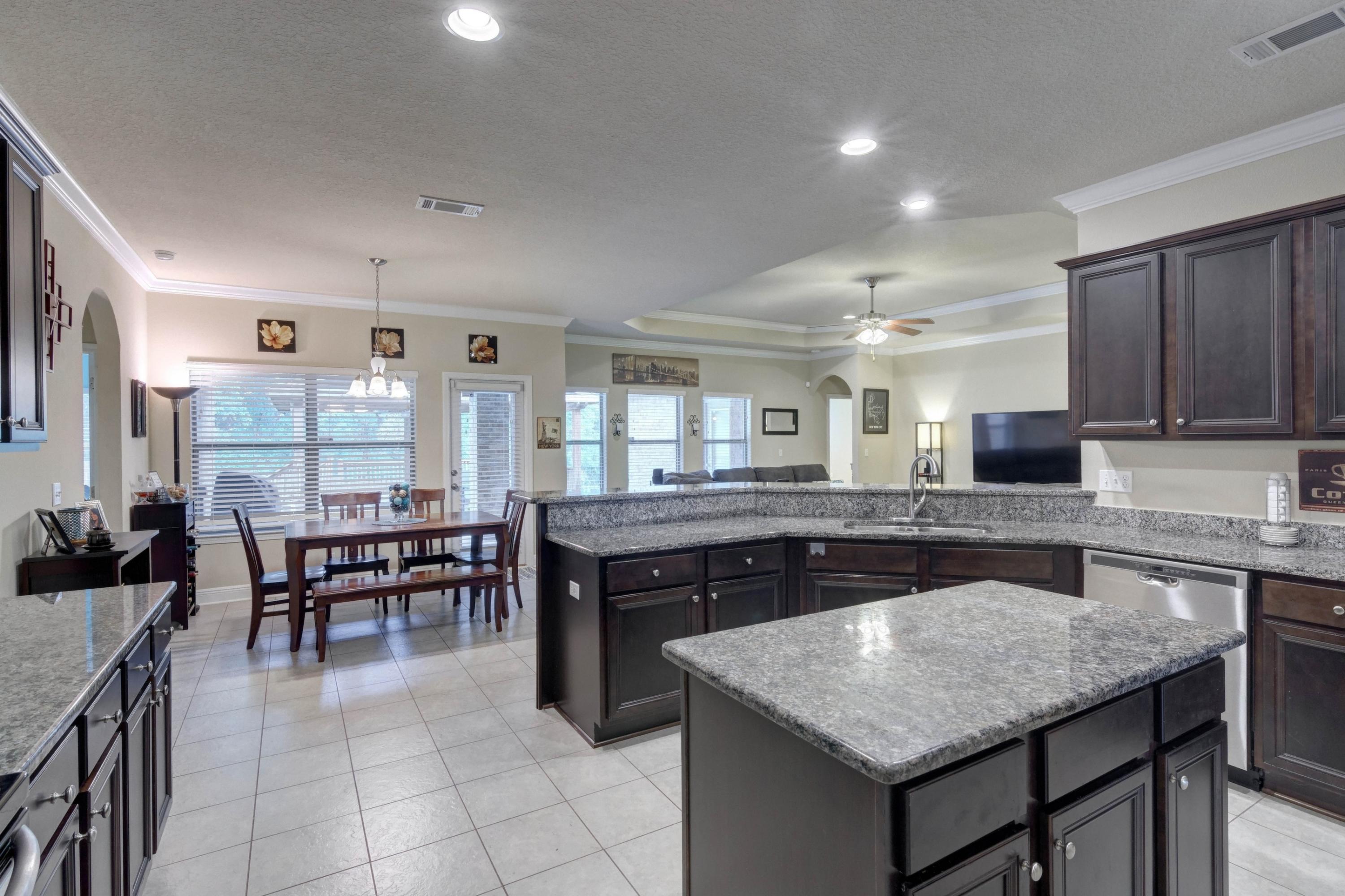 646 Red Fern Road Crestview, FL 32536 - Photo 31 of 64 a kitchen with a stove a sink a dining table and chairs