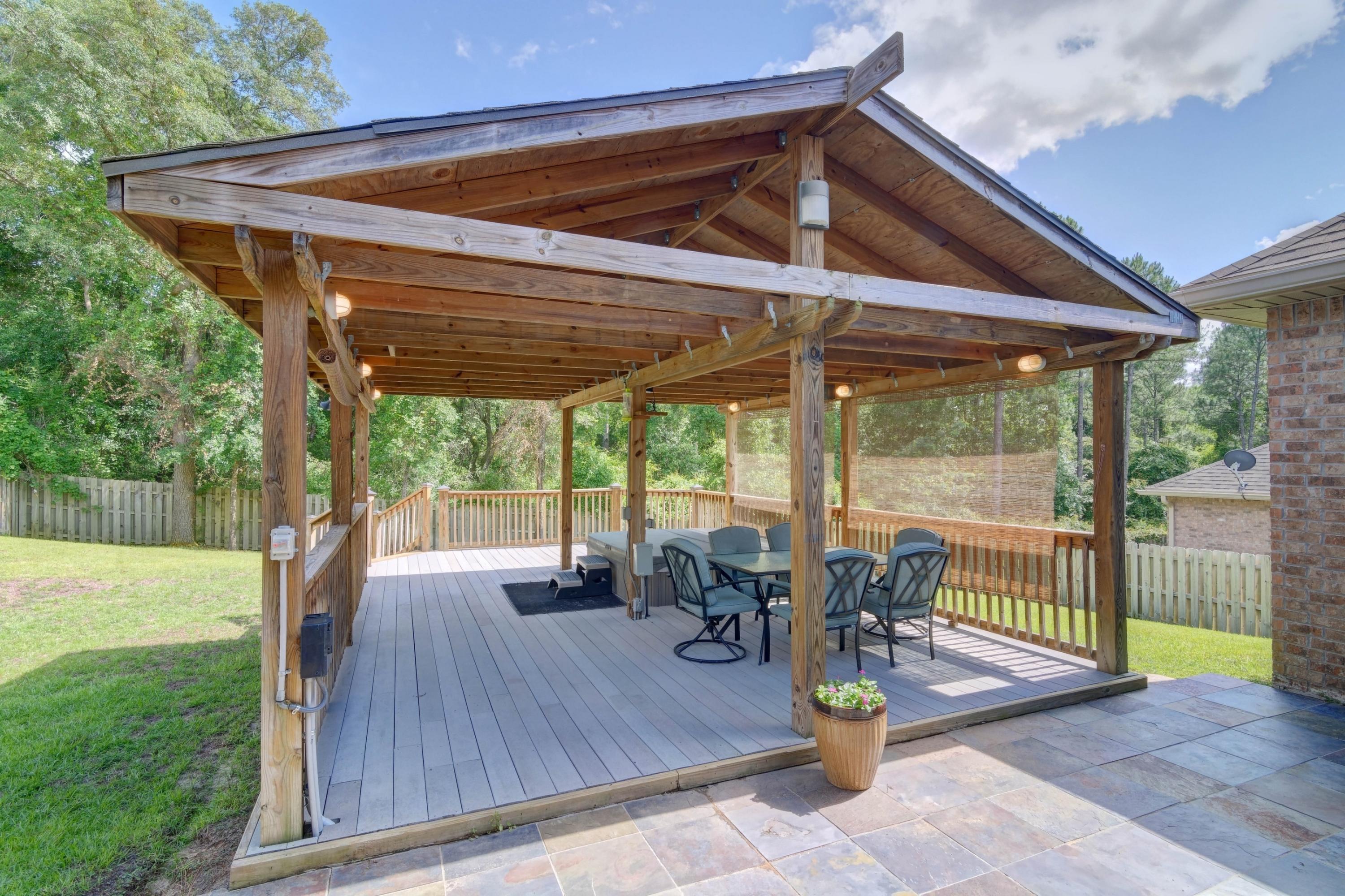 646 Red Fern Road Crestview, FL 32536 - Photo 53 of 64 a view of a patio with table and chairs potted plants with wooden floor and fence
