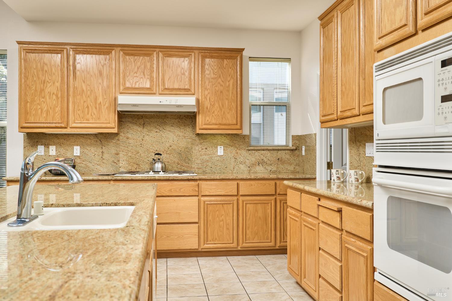 604 American Falls Drive Rio Vista, CA 94571 - Photo 18 of 39 a kitchen with granite countertop a sink cabinets stainless steel appliances and a window