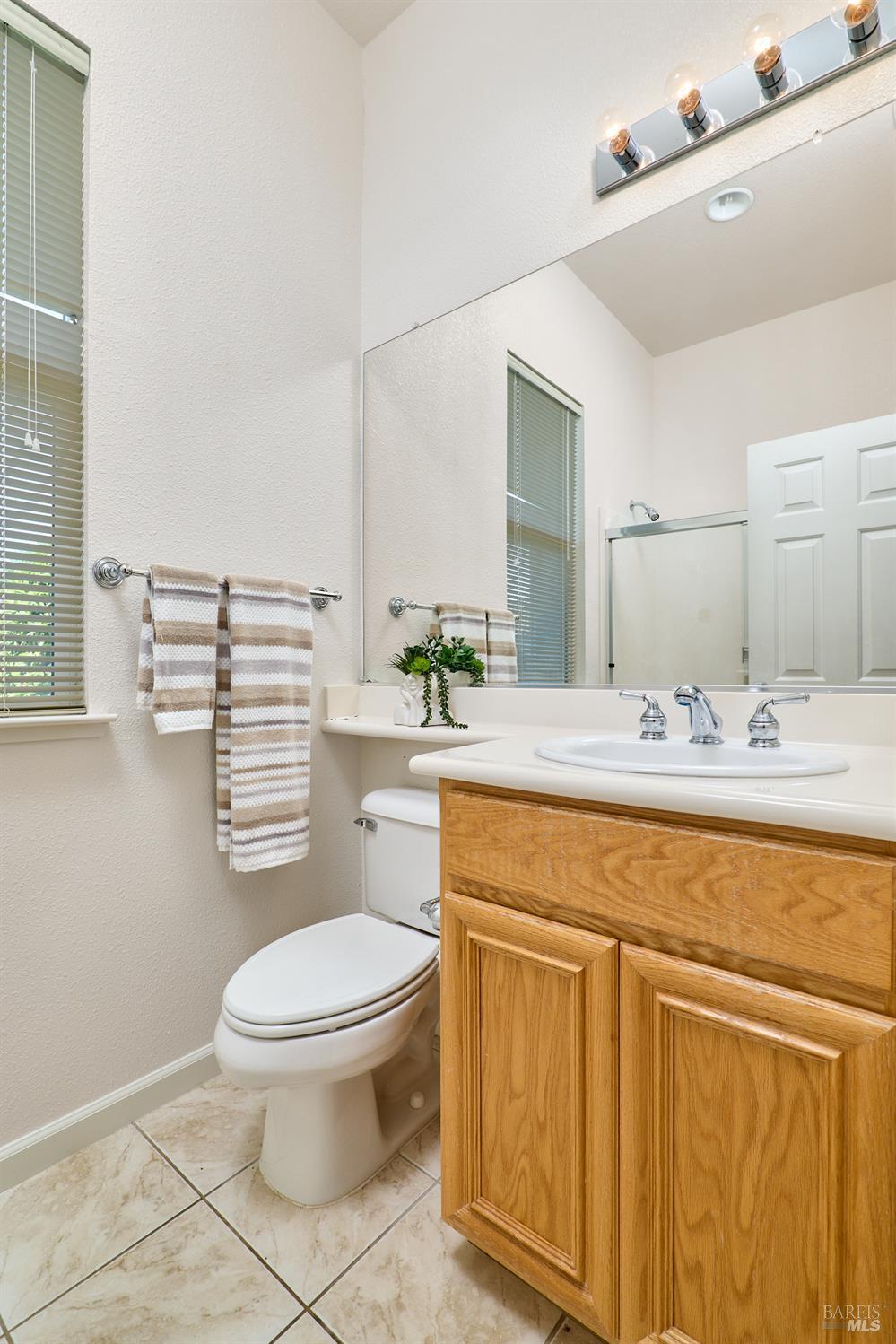 604 American Falls Drive Rio Vista, CA 94571 - Photo 31 of 39 a bathroom with a granite countertop toilet a sink and a mirror