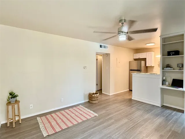 a view of a kitchen with wooden floor and a ceiling fan