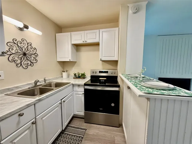 a kitchen with a stove sink and cabinets