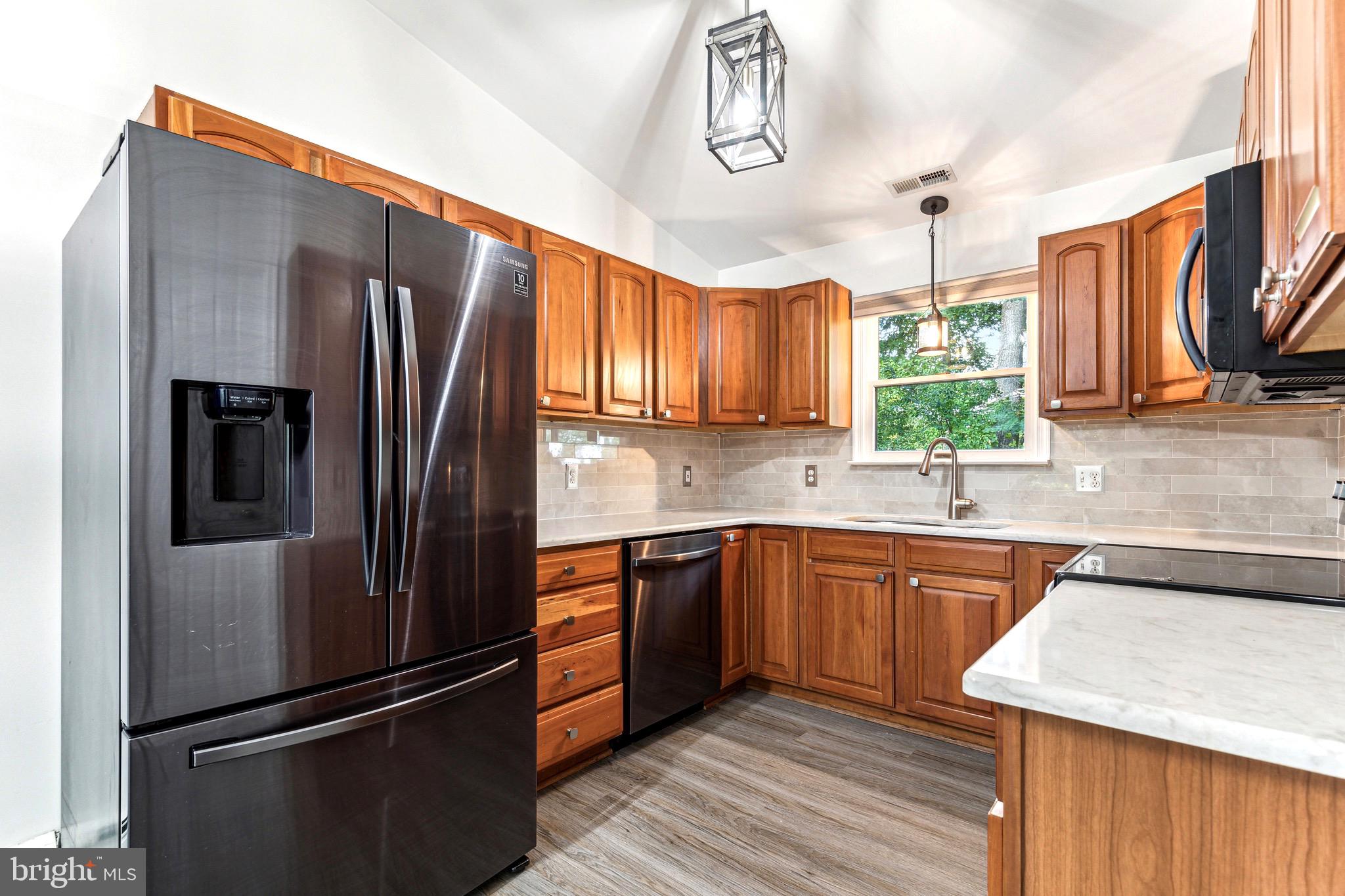 1500 St Margarets Road Annapolis, MD 21409 - Photo 1 of 18 a kitchen with stainless steel appliances granite countertop a refrigerator a sink dishwasher a stove and white countertops with wooden floor