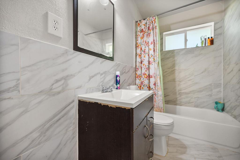 1437 Roma Lane Fort Worth, TX 76134 - Photo 16 of 20 a bathroom with a sink a toilet and shower