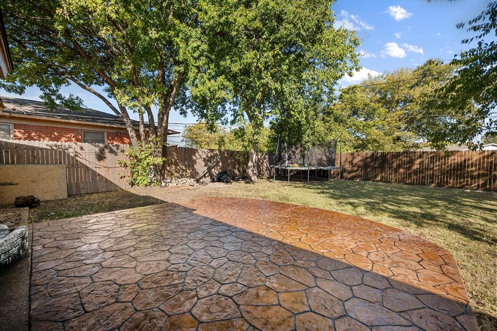 1437 Roma Lane Fort Worth, TX 76134 - Photo 19 of 20 a view of backyard with wooden fence and large trees