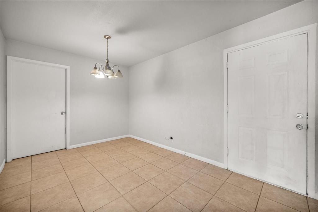 1437 Roma Lane Fort Worth, TX 76134 - Photo 8 of 20 an empty room with a chandelier fan