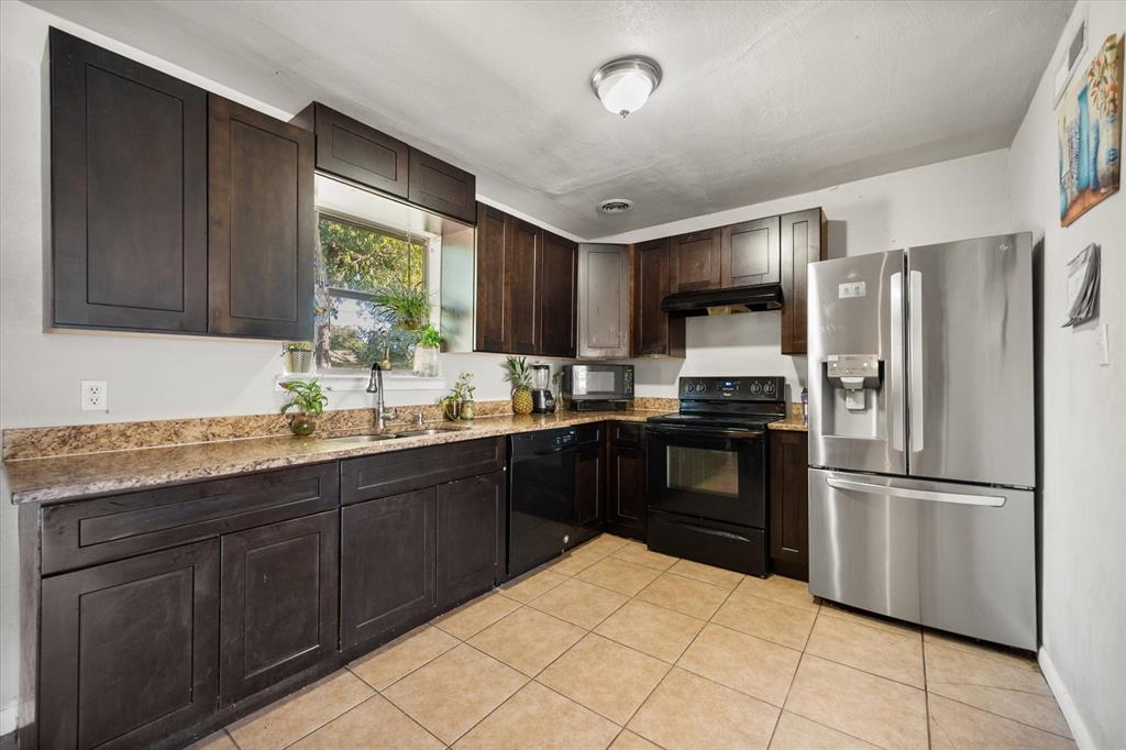 1437 Roma Lane Fort Worth, TX 76134 - Photo 9 of 20 a kitchen with granite countertop a refrigerator stove top oven and sink