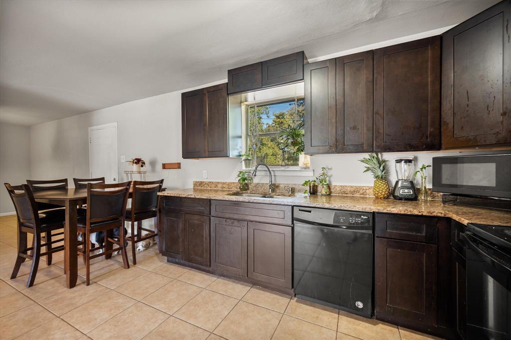 1437 Roma Lane Fort Worth, TX 76134 - Photo 10 of 20 a kitchen with a sink dining table and chairs