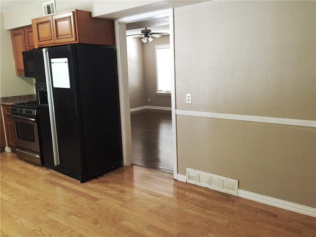 216 Elm Street Hurst, TX 76053 - Photo 13 of 17 Kitchen featuring light wood-finish flooring, wood cabinetry, and stainless steel appliances including a gas range