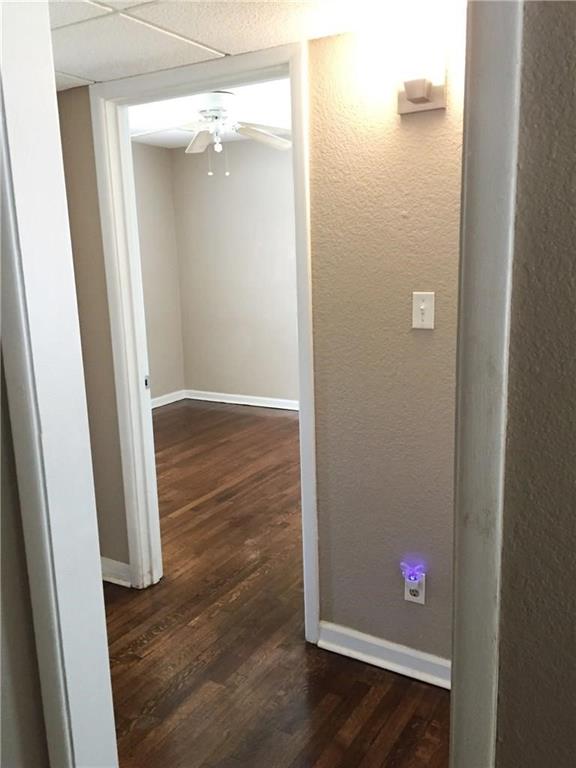 216 Elm Street Hurst, TX 76053 - Photo 4 of 17 Interior room featuring wood-finish flooring, light-colored walls, and a ceiling fan with light fixture