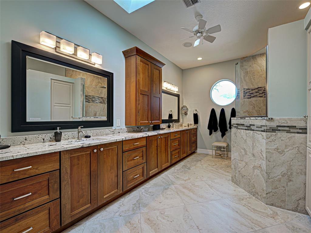 431 Tremingham Way Venice, FL 34293 - Photo 38 of 66 a large bathroom with a double vanity sink a mirror a bathtub and a window