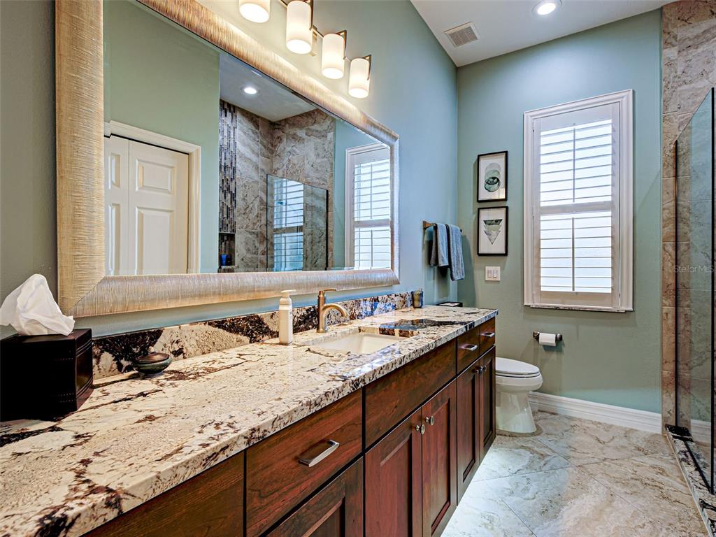 431 Tremingham Way Venice, FL 34293 - Photo 52 of 66 a bathroom with a granite countertop sink a large mirror and a toilet