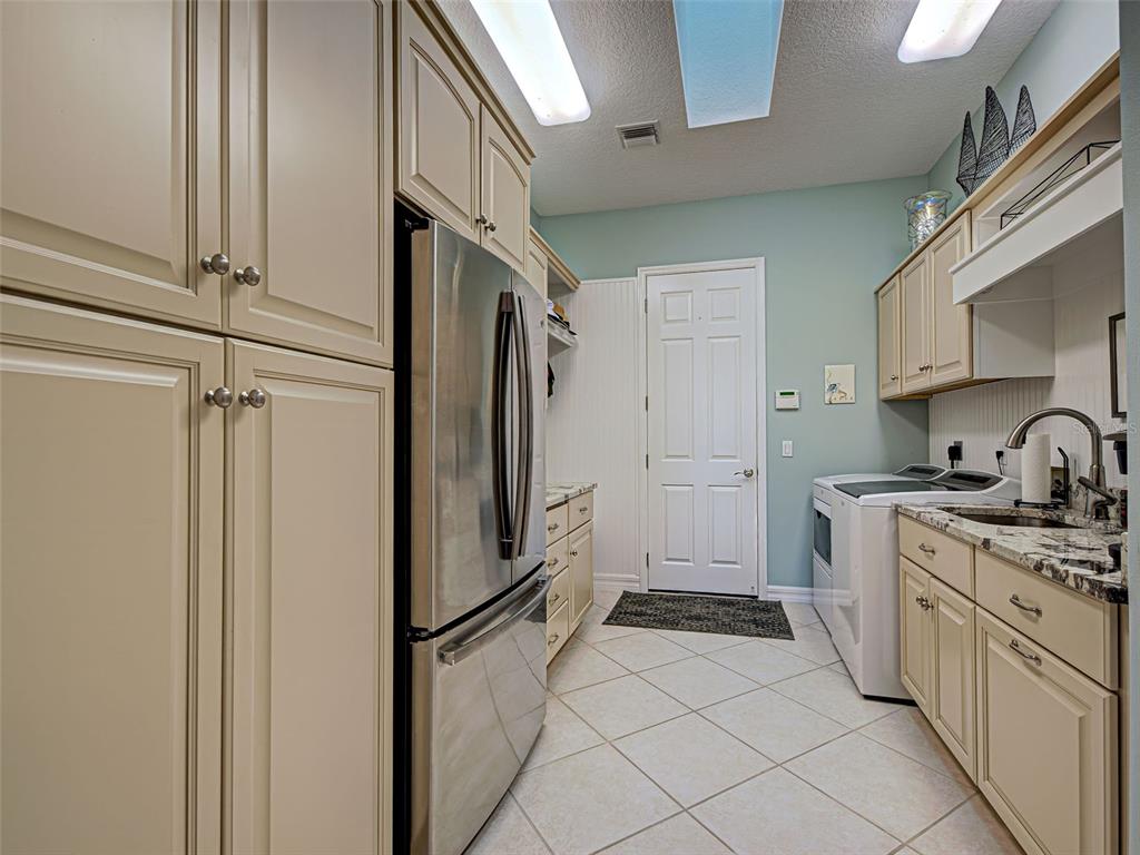 431 Tremingham Way Venice, FL 34293 - Photo 55 of 66 a kitchen with a refrigerator sink and cabinets