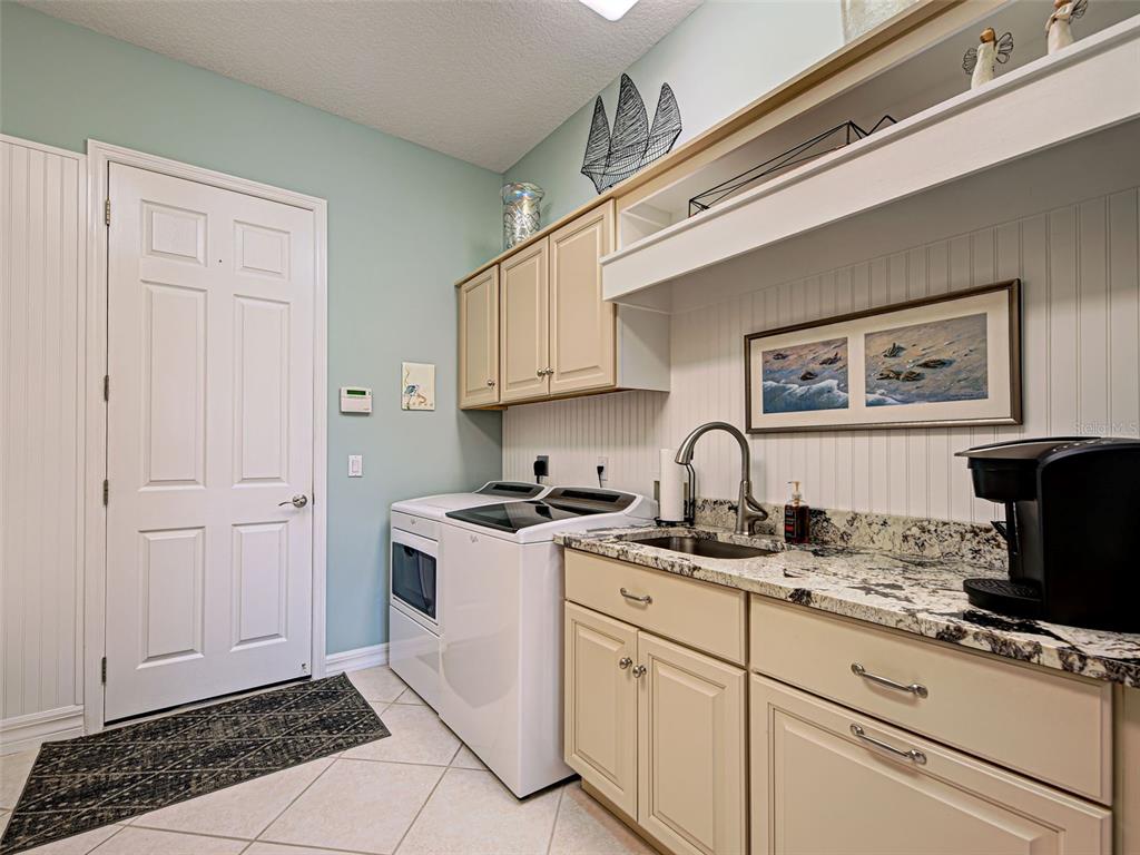 431 Tremingham Way Venice, FL 34293 - Photo 56 of 66 a kitchen with stainless steel appliances granite countertop a stove a sink and a microwave