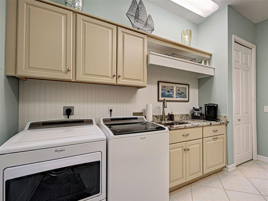 431 Tremingham Way Venice, FL 34293 - Photo 57 of 66 a kitchen with granite countertop a sink a stove and cabinets
